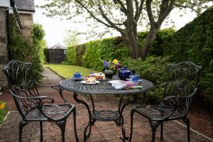 uma mesa com comida com três cadeiras em Morwick House B&B em Warkworth