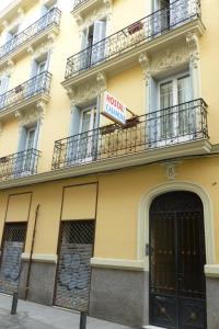 un bâtiment jaune avec un panneau d'hôtel dans l'établissement Hostal Casanova, à Madrid