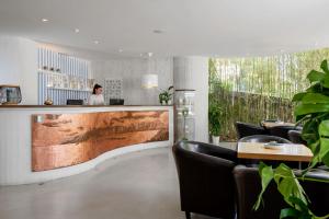 a woman sitting at a bar in a restaurant at Duparc Hotel in Gabicce Mare