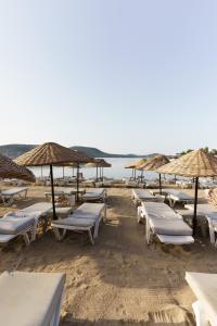 a row of lounge chairs and umbrellas on a beach at Costa Bitezhan Hotel - All Inclusive in Bitez