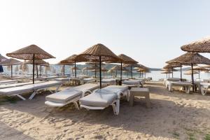 a bunch of chairs and umbrellas on a beach at Costa Bitezhan Hotel - All Inclusive in Bitez