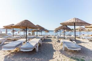 a bunch of chairs and umbrellas on a beach at Costa Bitezhan Hotel - All Inclusive in Bitez