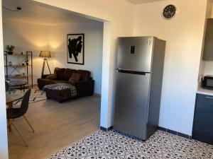 a kitchen with a refrigerator and a living room at Appartement en centre ville avec roof top in Port-la-Nouvelle