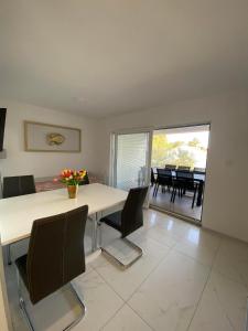 jadalnia z białym stołem i krzesłami w obiekcie Dorothy Apartman Vir w mieście Vir