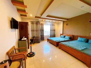 a bedroom with two beds and a television in it at GreenHome Hotel in Hai Phong