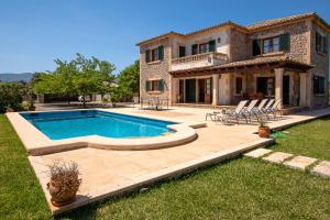 a house with a swimming pool in the yard at Villa can Canaveret By homevillas360 in Pollença