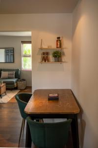 a dining room with a table and two green chairs at No 33 Stylish and Modern 1 Bed Apartment in Cheltenham