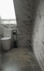 łazienka z toaletą i kamienną ścianą w obiekcie Willa Aurelcia w Świnoujściu