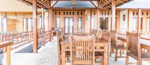 comedor con mesa de madera y sillas en D' Artha Cottage, en Nusa Penida
