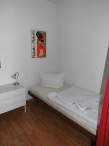 ハイリゲンハーフェンにあるFerienwohnung Spatzennestの小さなベッドルーム(ベッド1台付)が備わります。壁に絵が飾られています。