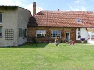 a brick house with a grass yard in front of it at Ferienwohnung "Zur Schmiede" Objekt-ID 11824 in Torgelow am See