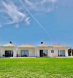 a large white house with a green lawn at Ktima Ayia Marina in Amalias