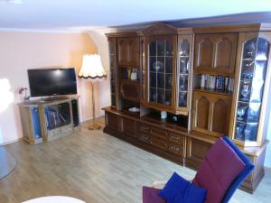 a living room with a tv and a entertainment center at Ferienwohnung "Zur Schmiede" Objekt-ID 11824 in Torgelow am See