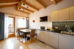 a kitchen with a table and a dining room at Apartments Lasteis in La Villa