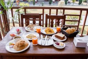 een houten tafel met borden ontbijtproducten erop bij Hotel Earth Light Sauraha in Chitwan