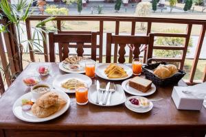a wooden table with plates of breakfast food on it at Hotel Earth Light Sauraha in Chitwan