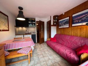 sala de estar con sofá rojo y mesa en Résidence 2-235 - Proche centre village, en La Clusaz