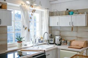 a kitchen with a sink and a window at Babérkert Villaház Balatonhenyén in Balatonhenye