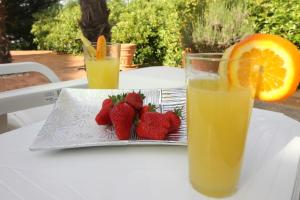a glass of orange juice and strawberries on a table at Apartaments Paradise in Koper