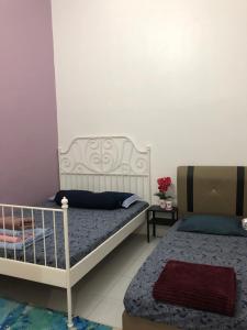 een slaapkamer met 2 bedden en een tafel met bloemen bij Ina Homestay Jerantut in Jerantut