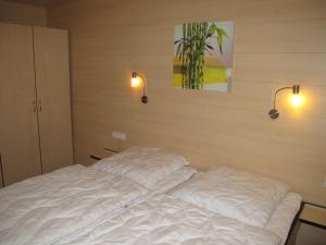 a white bed in a room with two lights on it at Holiday Home Erzeberg-2 by Interhome in Balhorn