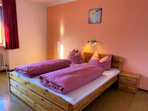 sypialnia z łóżkiem z różowymi poduszkami w obiekcie Apartment Roggenboden-1 by Interhome w mieście Oberau
