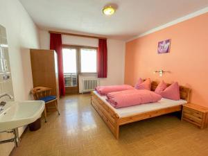 sypialnia z łóżkiem z różowymi poduszkami i umywalką w obiekcie Apartment Roggenboden-1 by Interhome w mieście Oberau