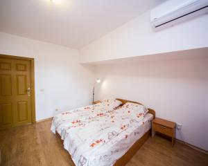 um quarto com uma cama num quarto branco em ALEKS Top Center em Burgas