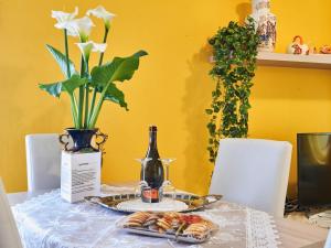 a table with a bottle of wine and a plate of food at Apartment Casa del Pergulin - LMZ325 by Interhome in Verceia