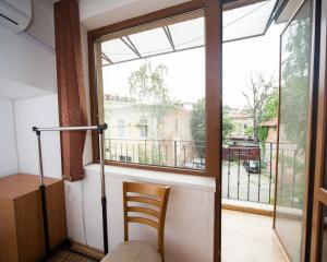 a room with a window and a wooden chair at ALEKS Top Center in Burgas +6 photos