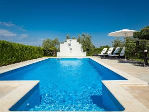 a swimming pool with a fountain in a yard at Apartment Cancar-1 by Interhome in Poreč