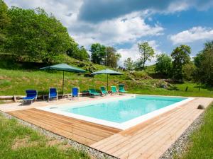 una piscina con sillas y sombrillas en una terraza de madera en Holiday Home Paradiso I by Interhome, en Bolognana