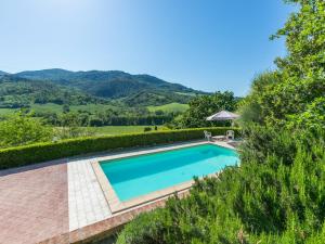 a swimming pool in a villa with mountains in the background at Holiday Home Il Felciaio by Interhome in Sassa