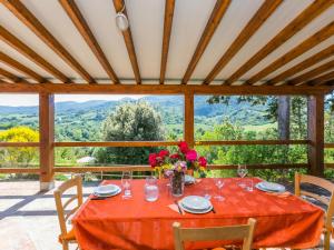 a table with a red table cloth and flowers on it at Holiday Home Il Felciaio by Interhome in Sassa