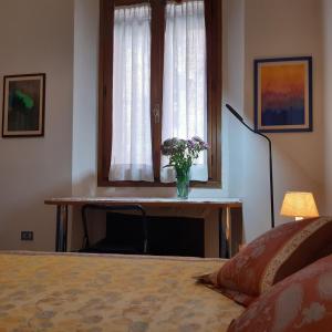 a bedroom with a window with a vase of flowers at Ca' Celestia Arsenale in Venice