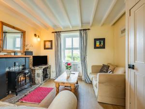 ein Wohnzimmer mit Couch und Kamin in der Unterkunft 2 Sea View Cottage in Pwllheli