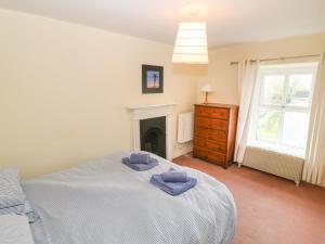 ein Schlafzimmer mit einem Bett mit zwei Handtüchern darauf in der Unterkunft 2 Sea View Cottage in Pwllheli