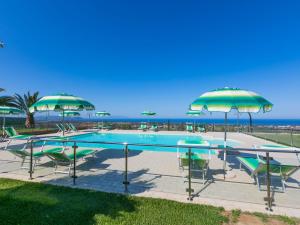 a swimming pool with chairs and umbrellas at Holiday Home Il Corbezzolo-1 by Interhome in San Vincenzo