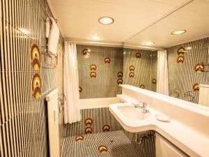 ein Bad mit einem Waschbecken und einer Dusche in der Unterkunft Apartment Appartmenthaus Skyline 309 by Interhome in St. Moritz