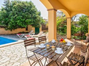 a patio with a table and chairs next to a pool at Holiday Home Mas Pere by Interhome in Calonge