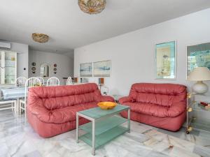 una sala de estar con 2 sofás rojos y una mesa. en Villa Querida by Interhome, en Mijas Costa