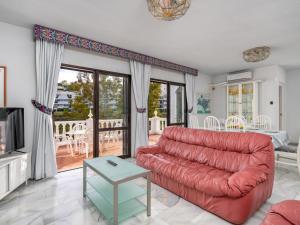 a living room with a red couch and a table at Villa Querida by Interhome in Mijas Costa