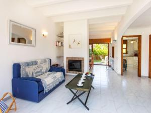 a living room with a blue couch and a table at Holiday Home Club by Interhome in Calonge