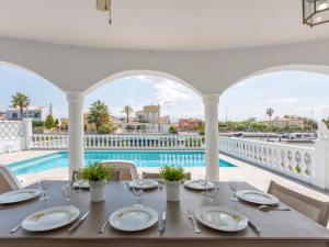 a dining table with a view of the pool at Holiday Home Peni by Interhome in Empuriabrava