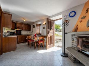 kuchnia i jadalnia ze stołem i kominkiem w obiekcie Apartment Caillod 12 by Interhome w mieście Sarre