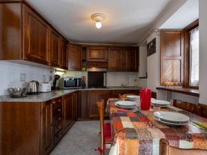 kuchnia z drewnianymi szafkami i stołem z płytami w obiekcie Apartment Caillod 12 by Interhome w mieście Sarre
