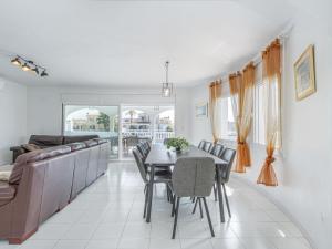 a dining room with a table and chairs and a couch at Holiday Home Peni by Interhome in Empuriabrava