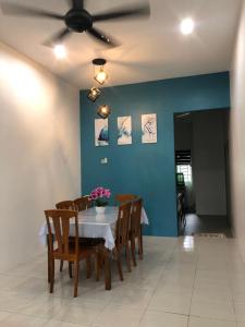 a dining room with a table and chairs and a ceiling fan at Ina Homestay Jerantut in Jerantut