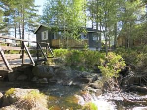 Øyuvstad的住宿－Chalet Trygvebu - SOW057 by Interhome，树林中的小屋,有一条小溪上的桥梁