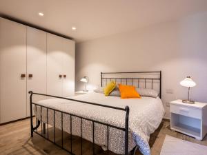 a bedroom with a bed with orange and yellow pillows at Apartment Cima by Interhome in Aosta